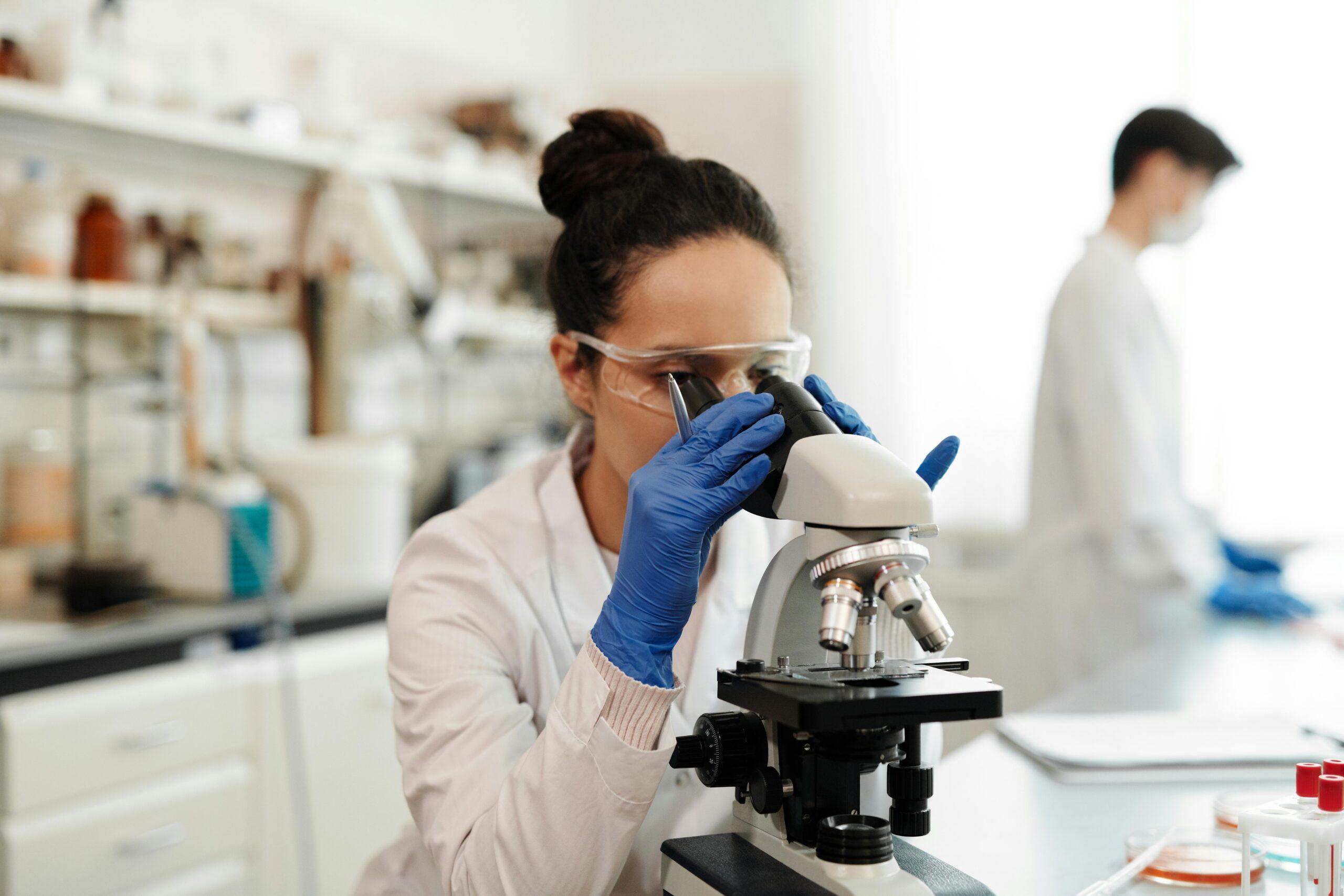 Scientist examining samples through a microscope